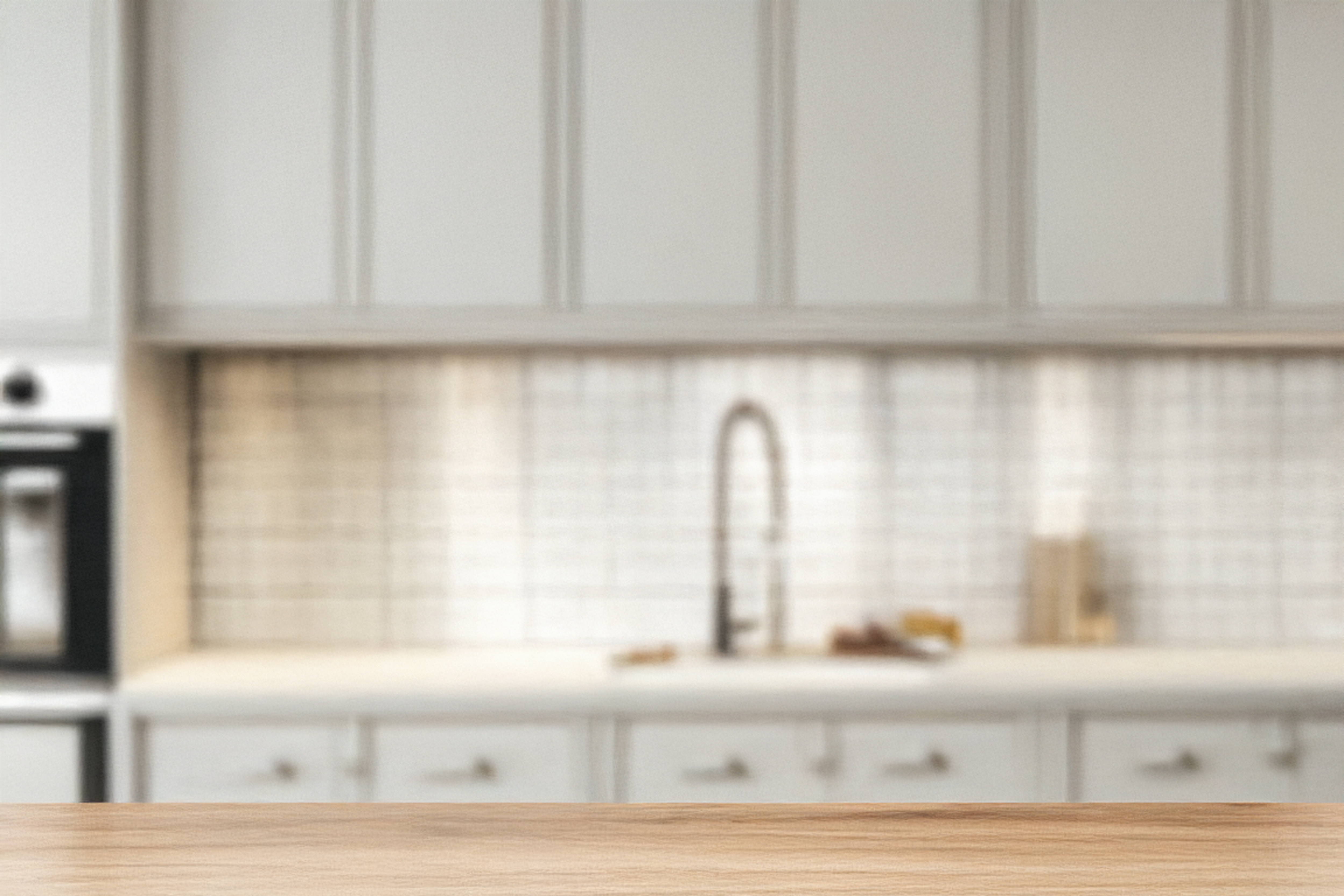 Blurry background image of a kitchen counter with cabinets.